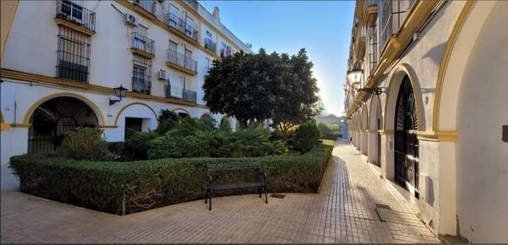 Un callejón estrecho entre dos edificios con un banco en el medio.