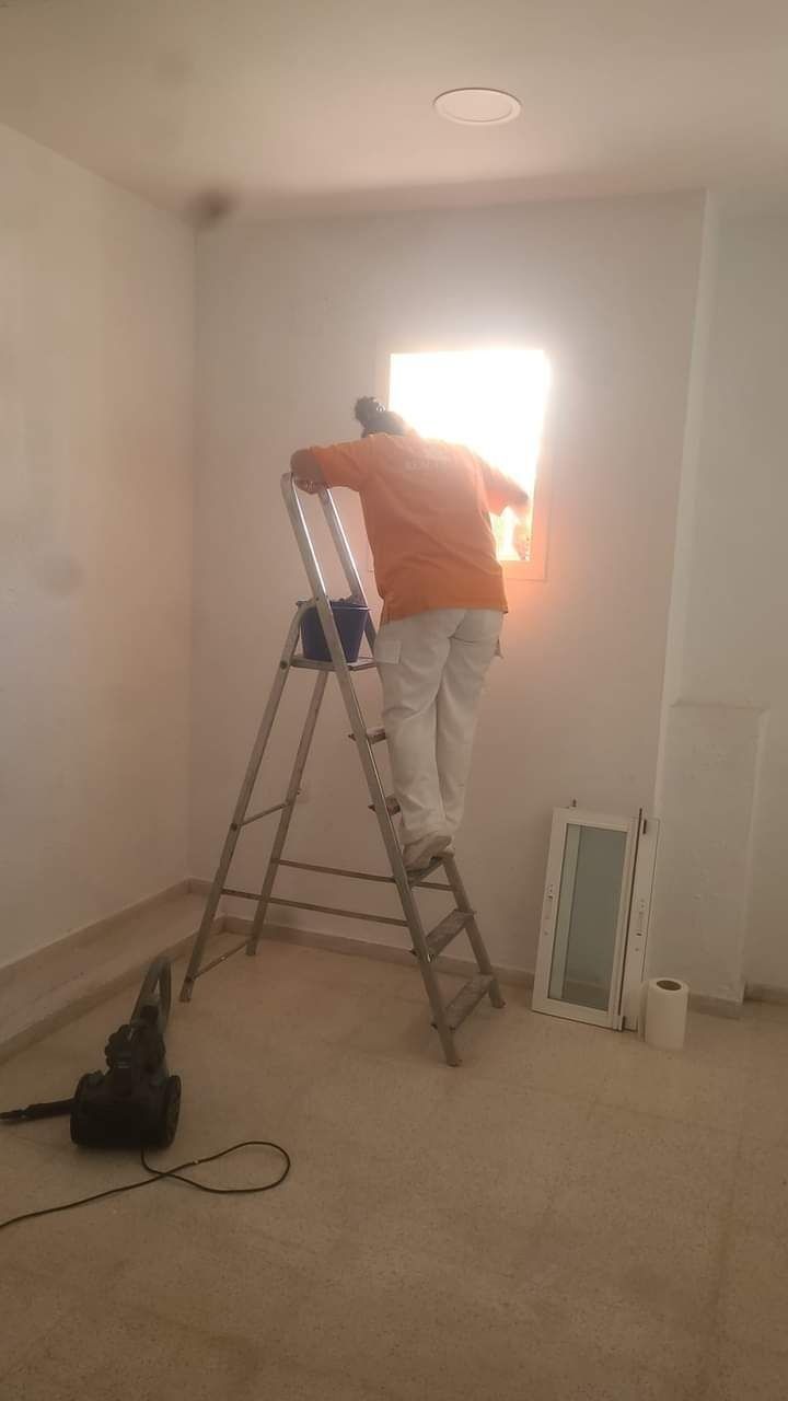 Un hombre está de pie en una escalera en una habitación.