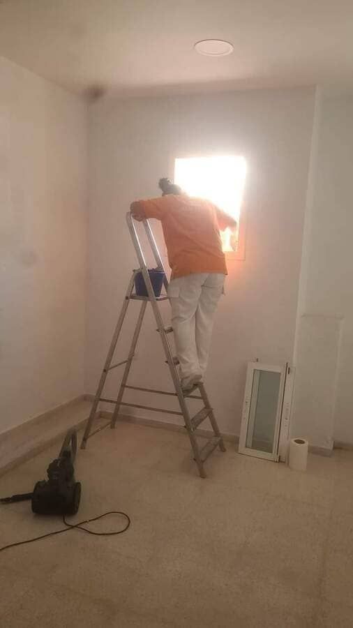 Un hombre está de pie en una escalera en una habitación.