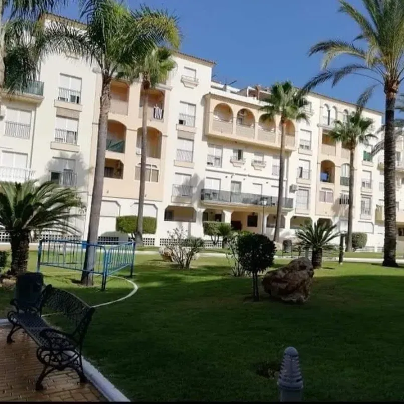 Un gran edificio con palmeras delante.