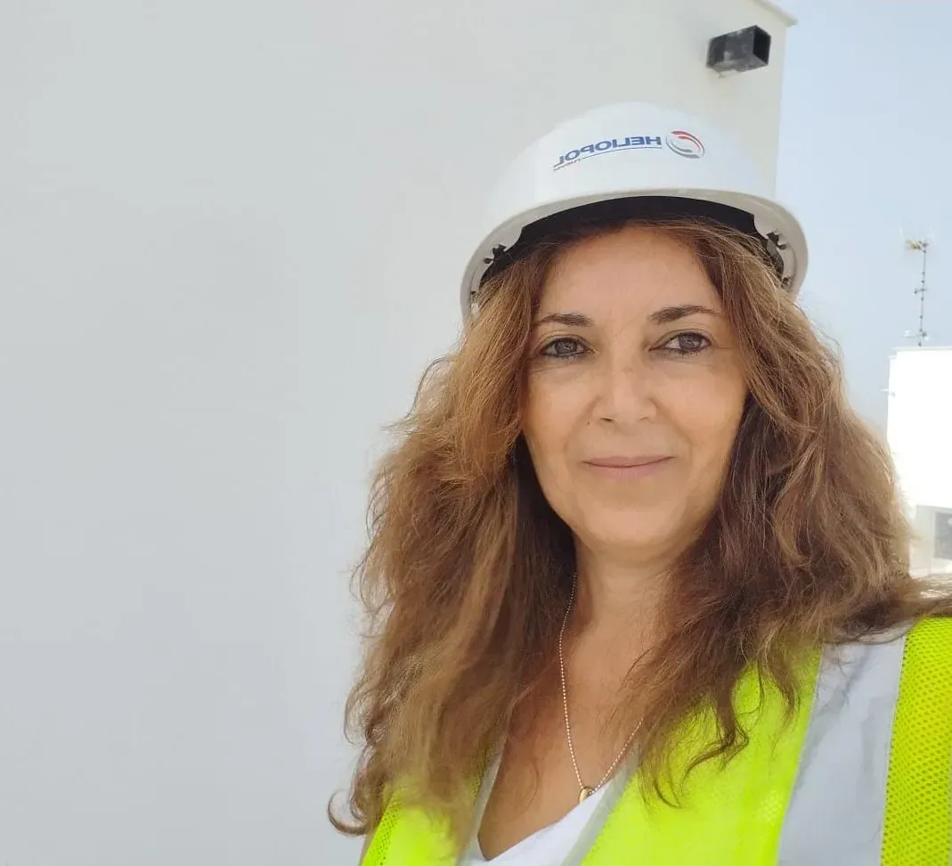 Una mujer que lleva un casco y un chaleco amarillo