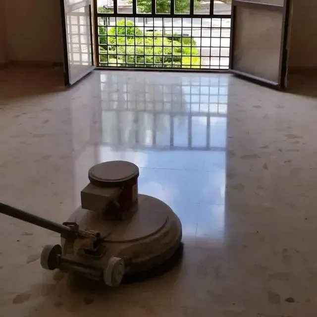 Una máquina está puliendo un piso de mármol en una habitación.