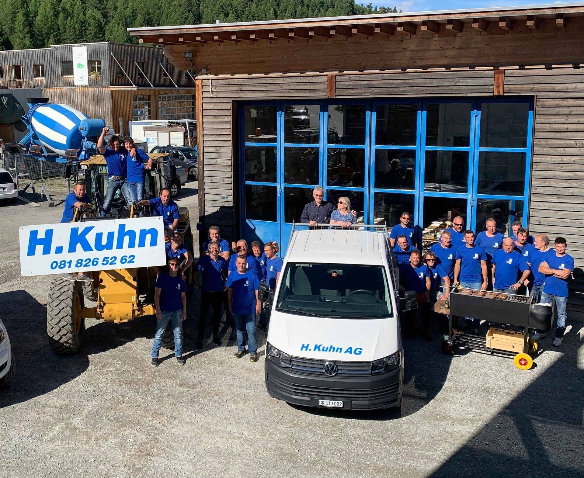 Eine Gruppe von Menschen steht vor einem Gebäude. Foto von der H. Kuhn Hoch- und Tiefbau AG