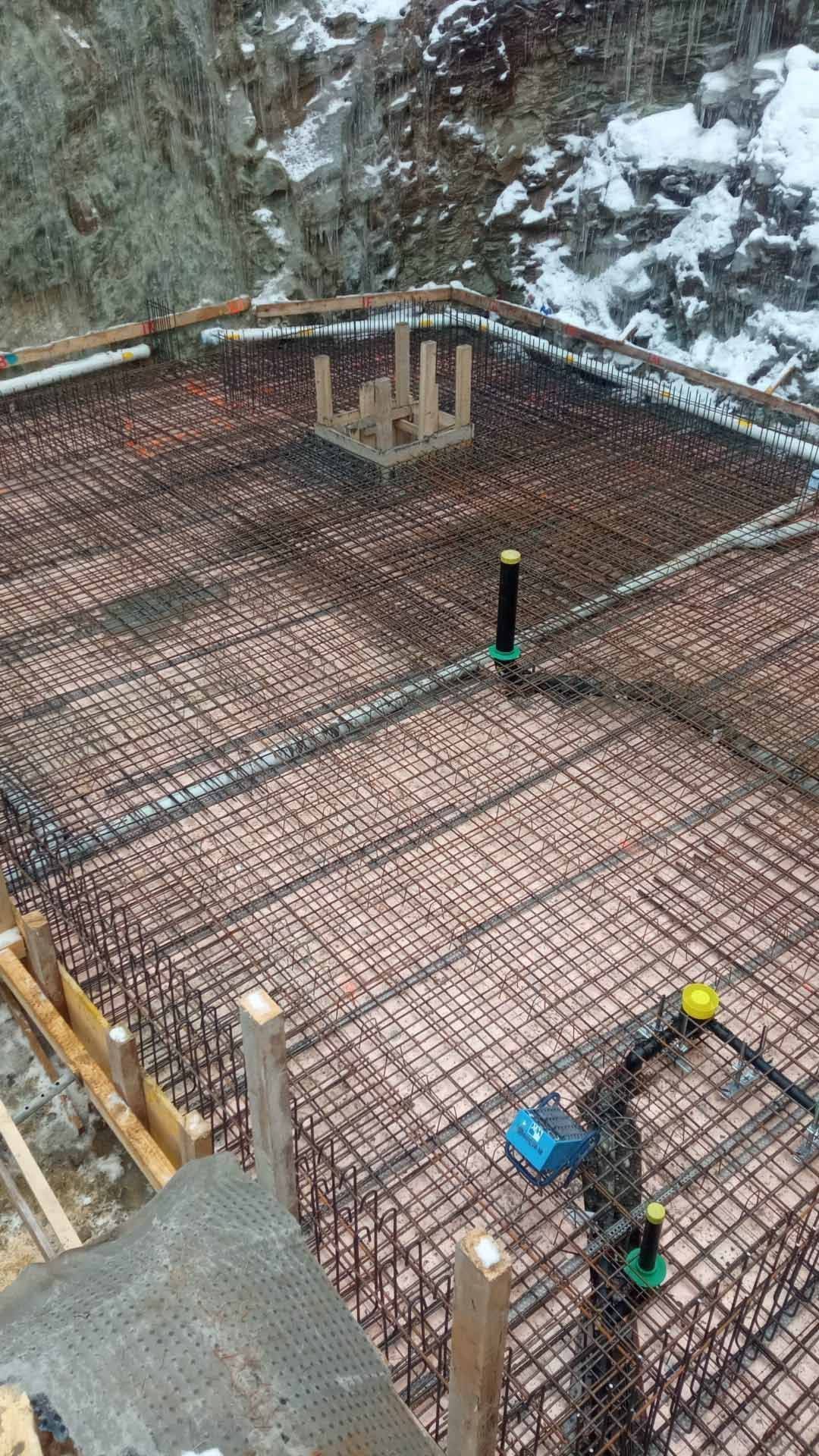 Eine Baustelle mit einem Zaun darum und einem Betonboden. Foto von der H. Kuhn Hoch- und Tiefbau AG