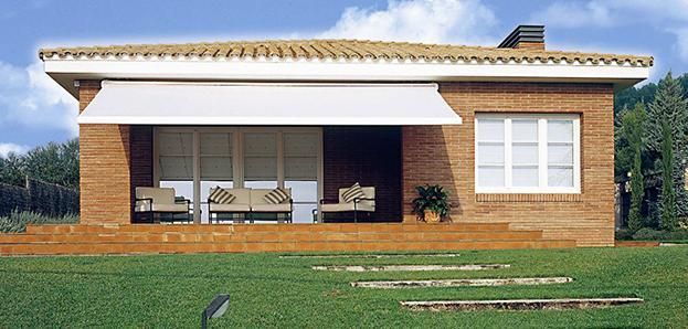 Una casa de ladrillo con un toldo blanco sobre el porche.