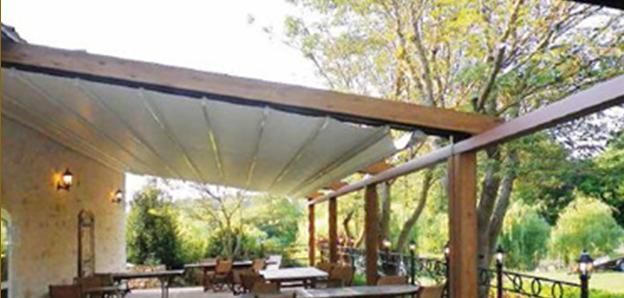 Un patio con mesas y sillas bajo un dosel.