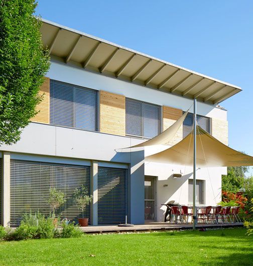 Una casa con una gran sombrilla delante de ella.