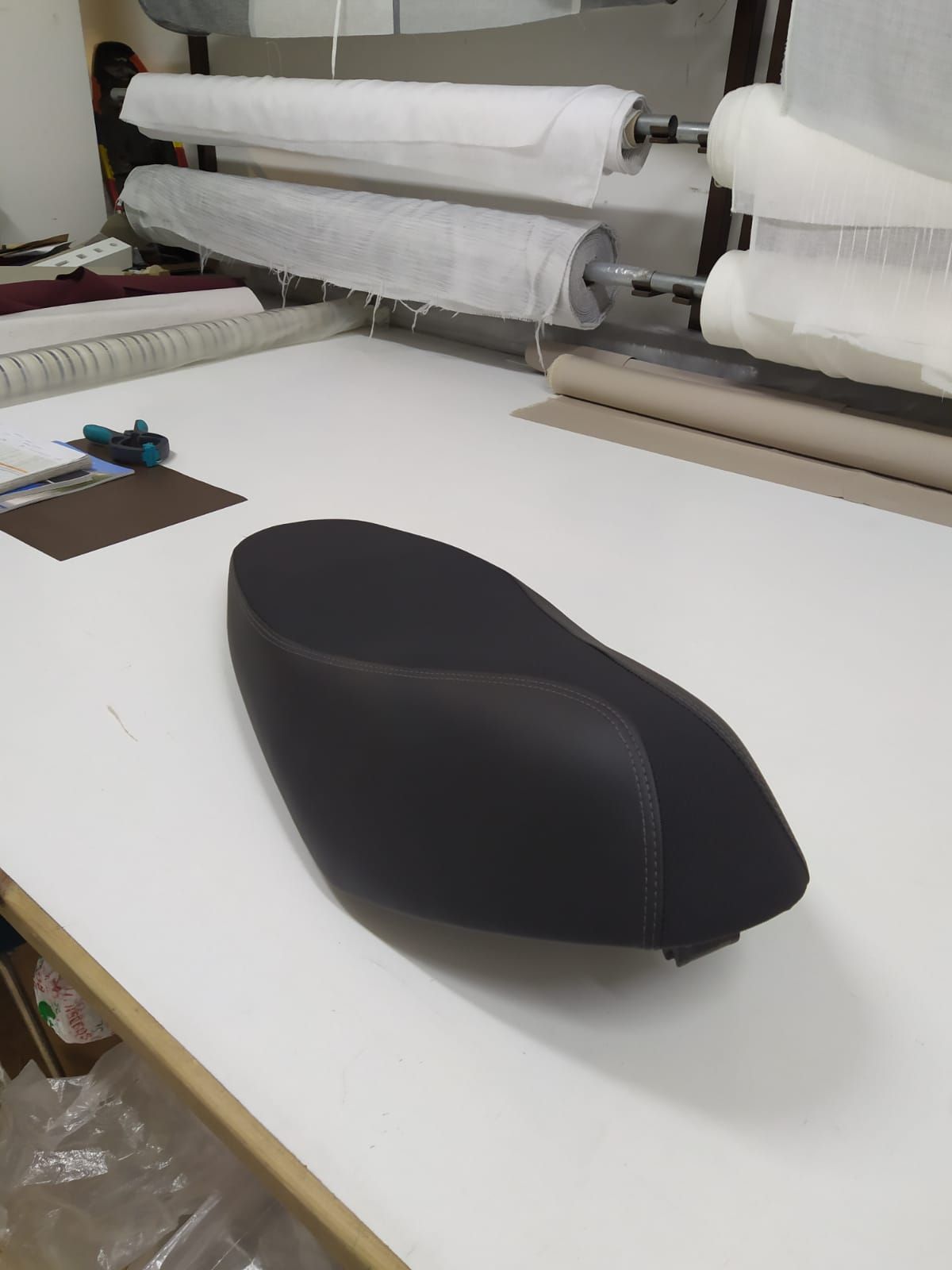 Una otomana negra está sentada sobre una mesa blanca.