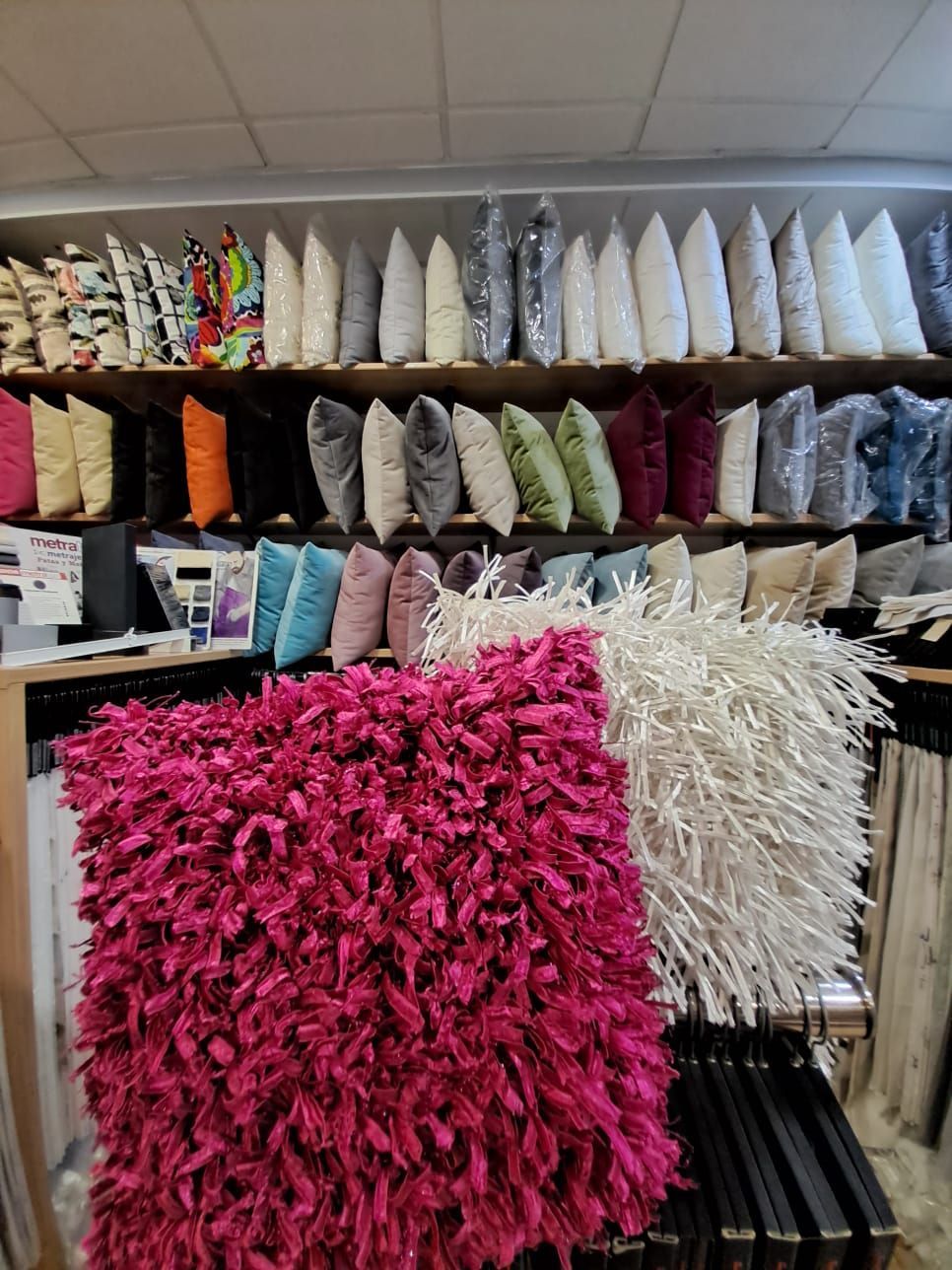 Un montón de almohadas están en exhibición en una tienda.