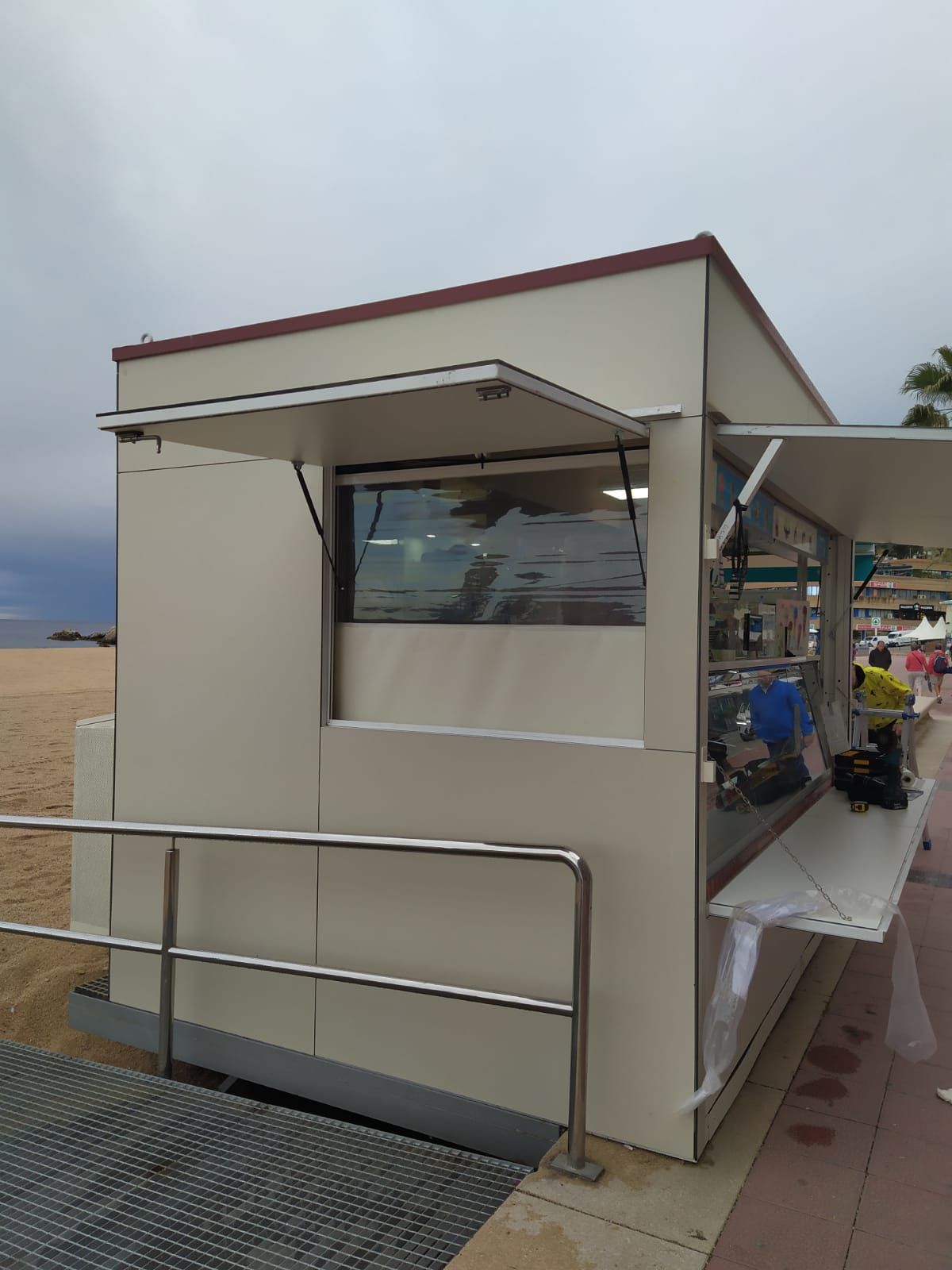 Un pequeño edificio blanco con una gran ventana en el costado.