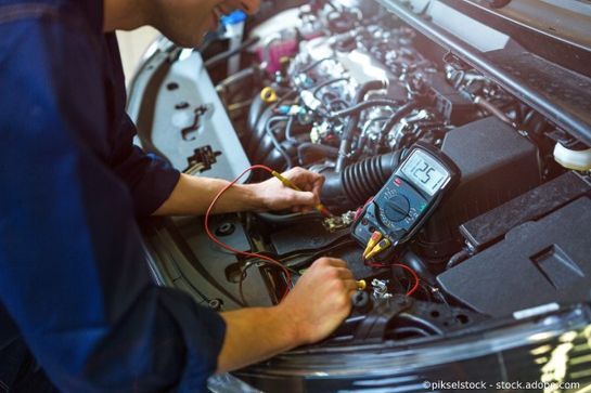 KTB Nürnberg Kfz-Meister nimmt eine Messung an einer offenen Motorhaube