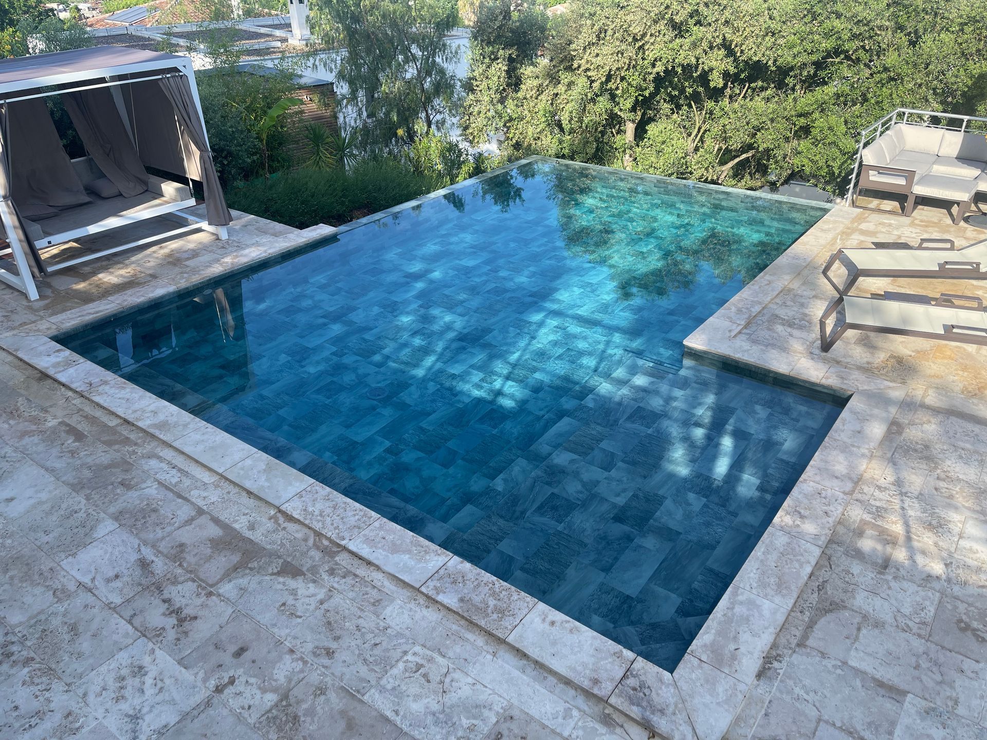 Une piscine à débordement avec un fond bleu.