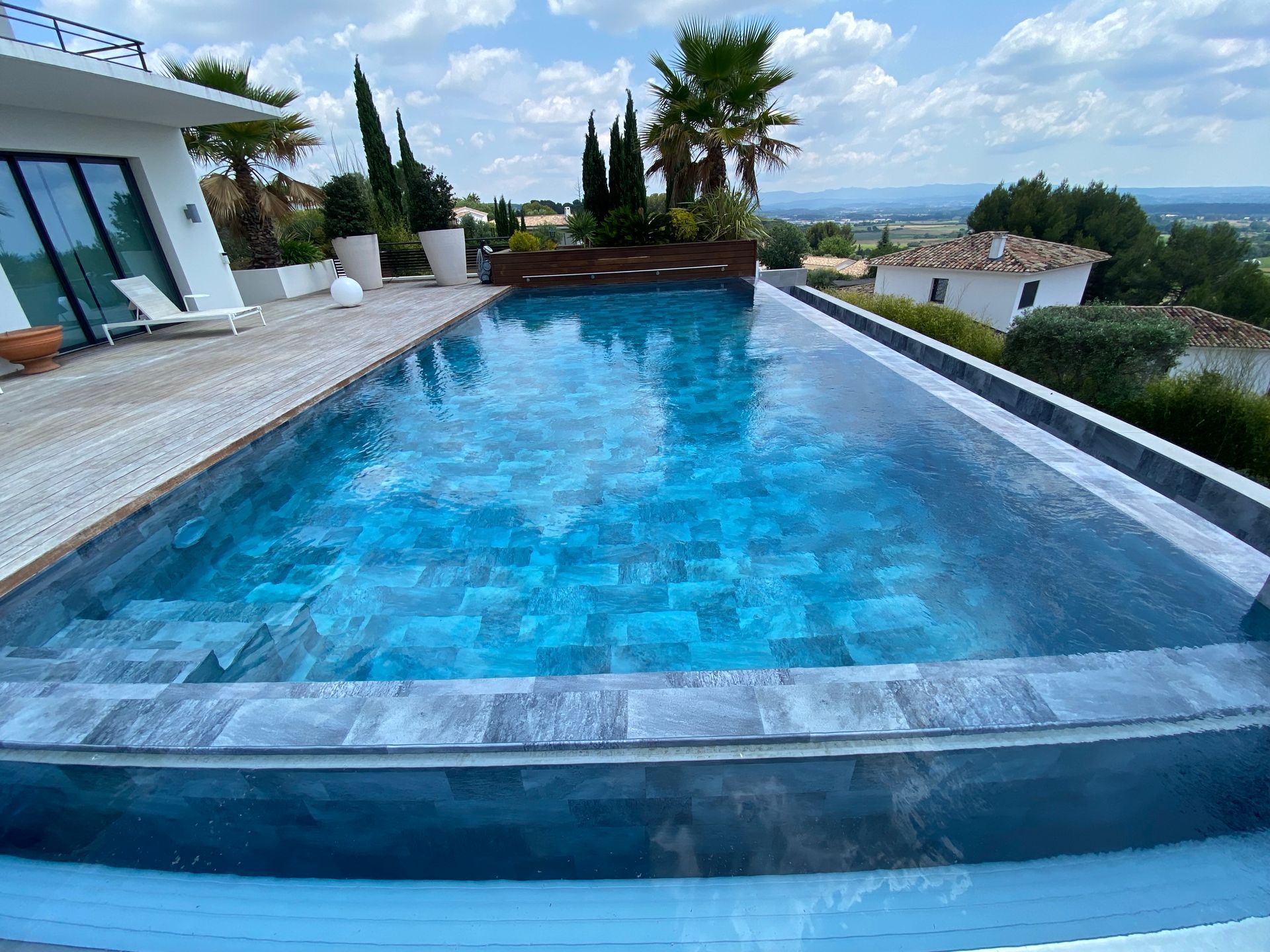Une piscine fond bleu avec des palmiers.