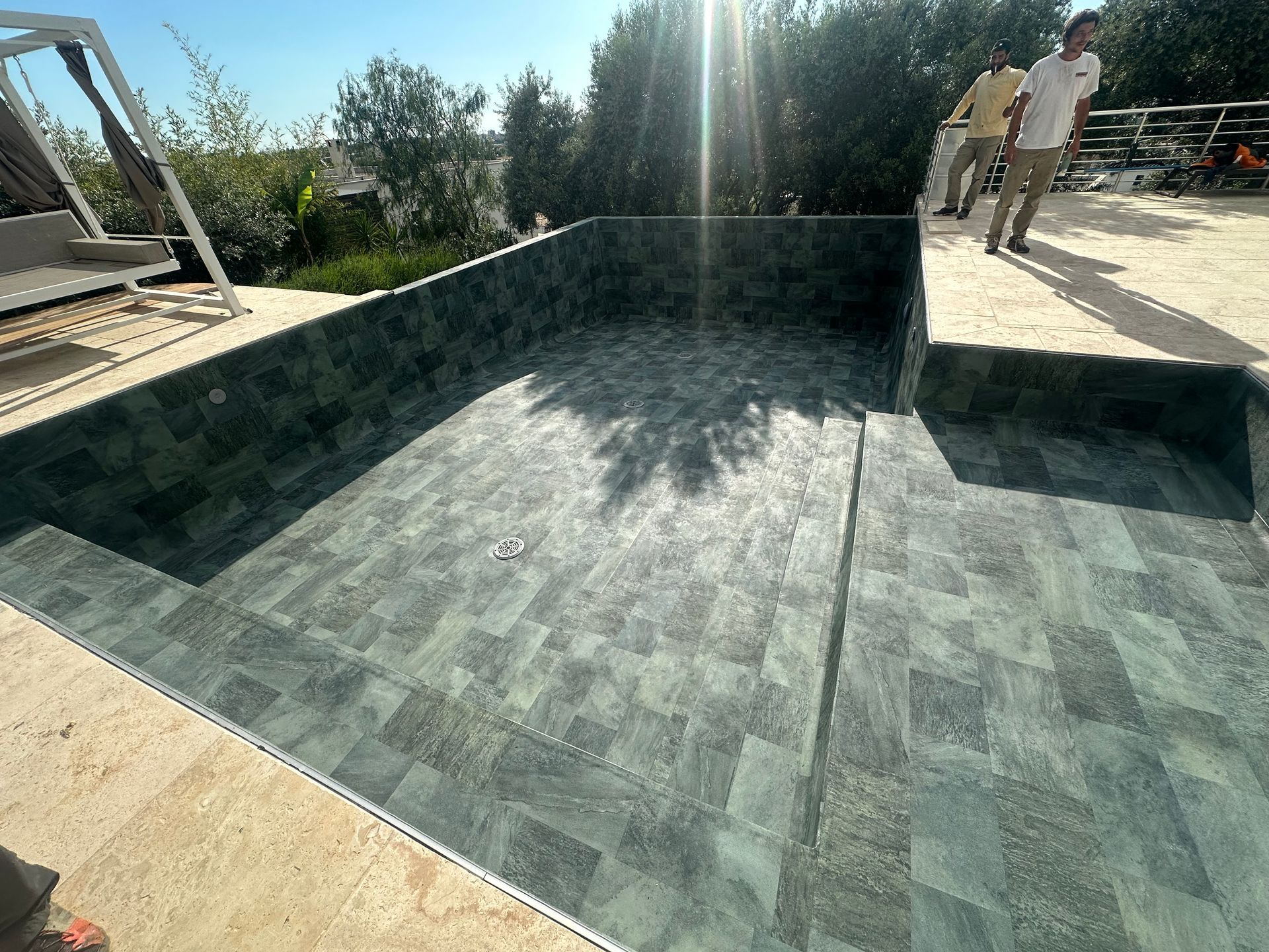 Piscine à vide de couleur sombre sur un temps ensoleillé.