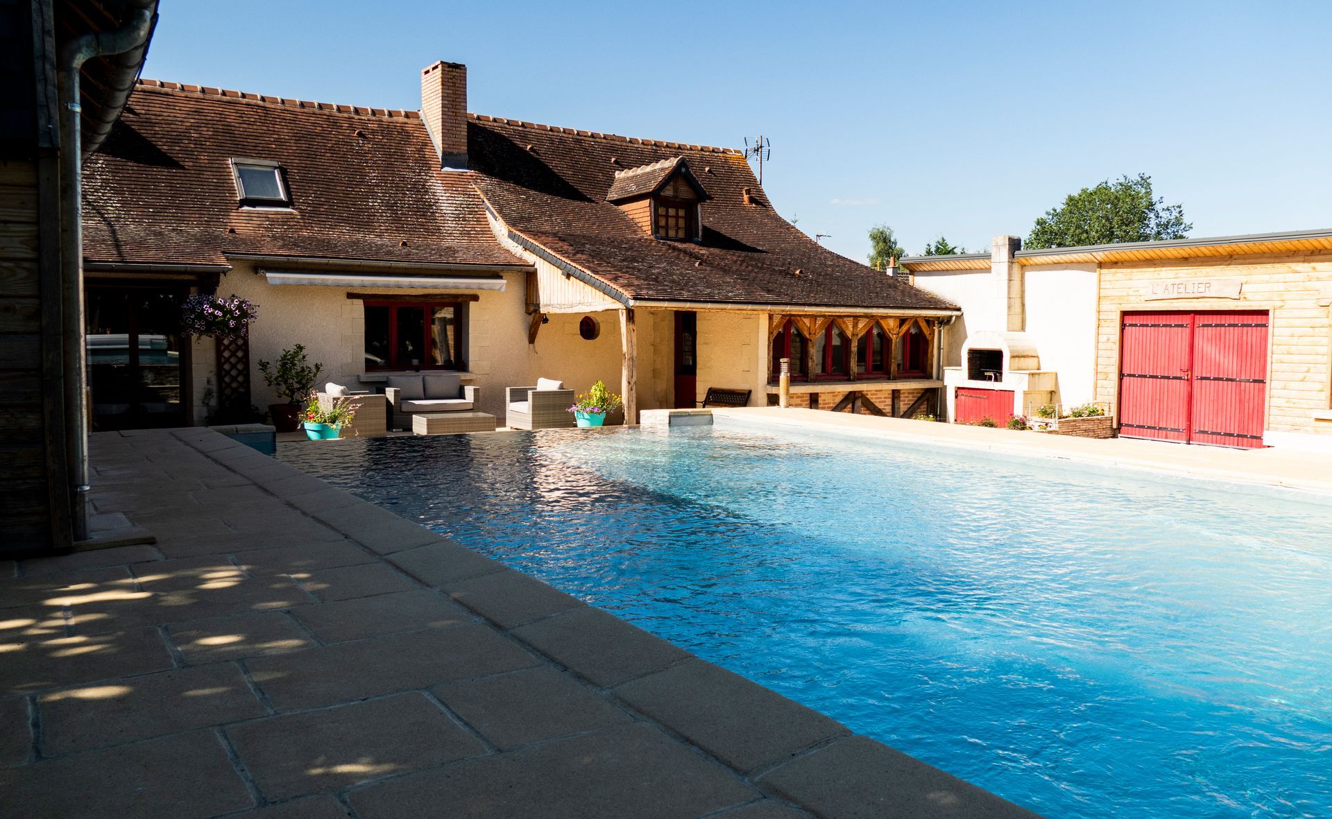 Grande piscine avec maison ancienne.