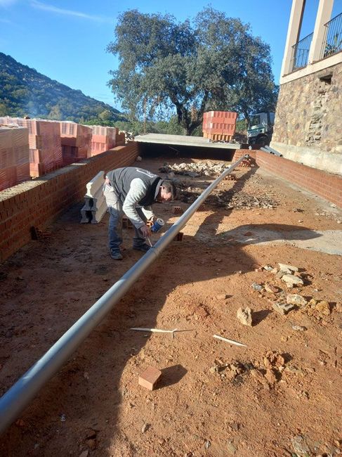 Un hombre está trabajando en una tubería en el suelo.