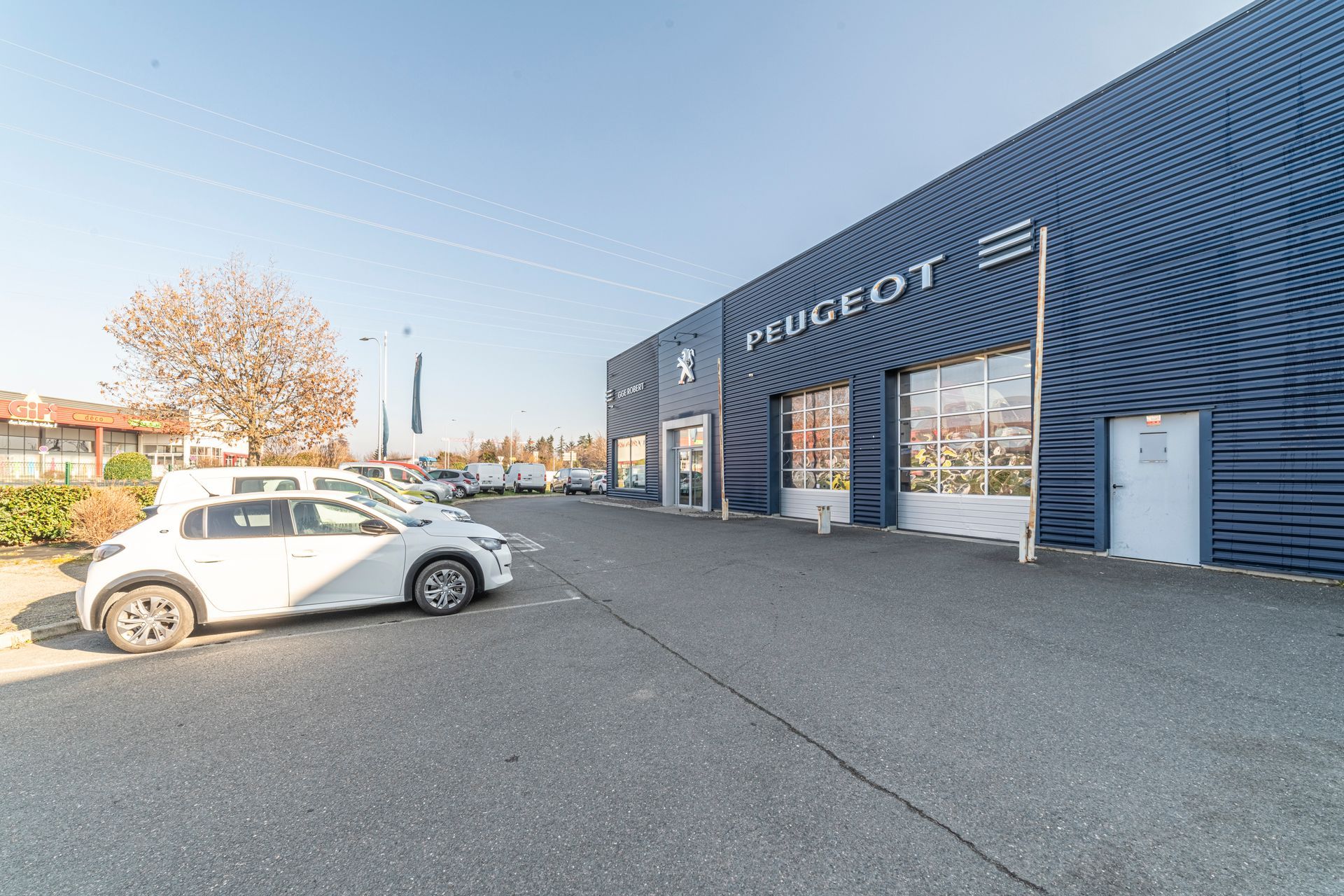Garage Robert Peugeot avec plusieurs véhicules stationnés aux alentours.