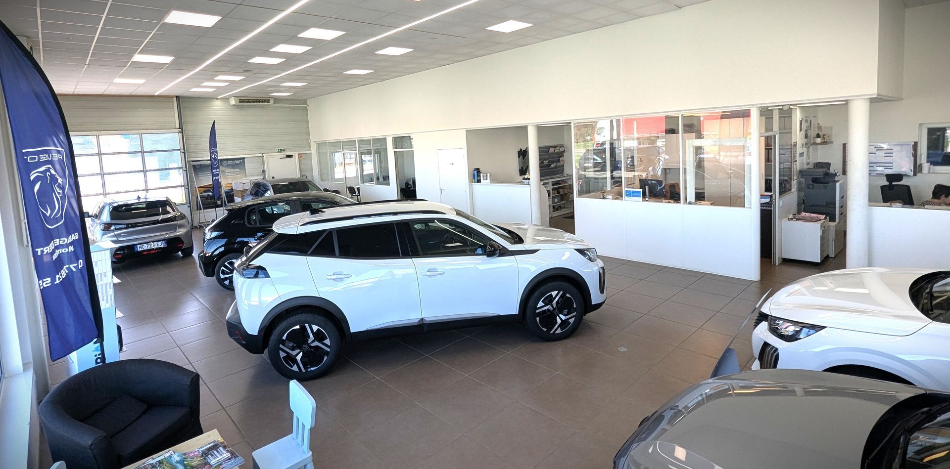 Véhicules Peugeot en exposition dans un garage concessionnaire Peugeot.