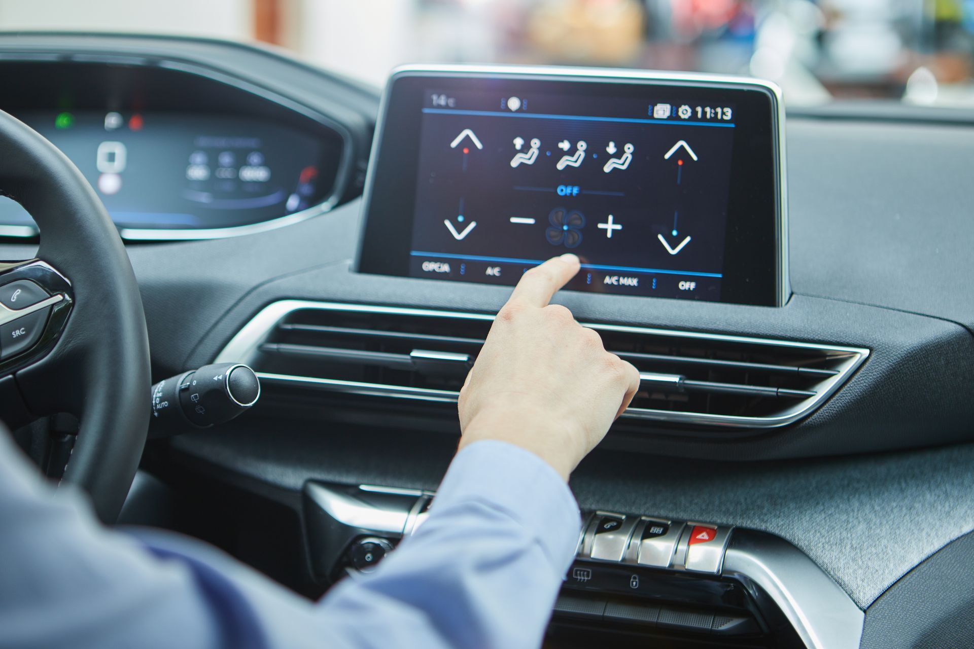 Personne activant l'air conditionné sur l'écran d'un véhicule.