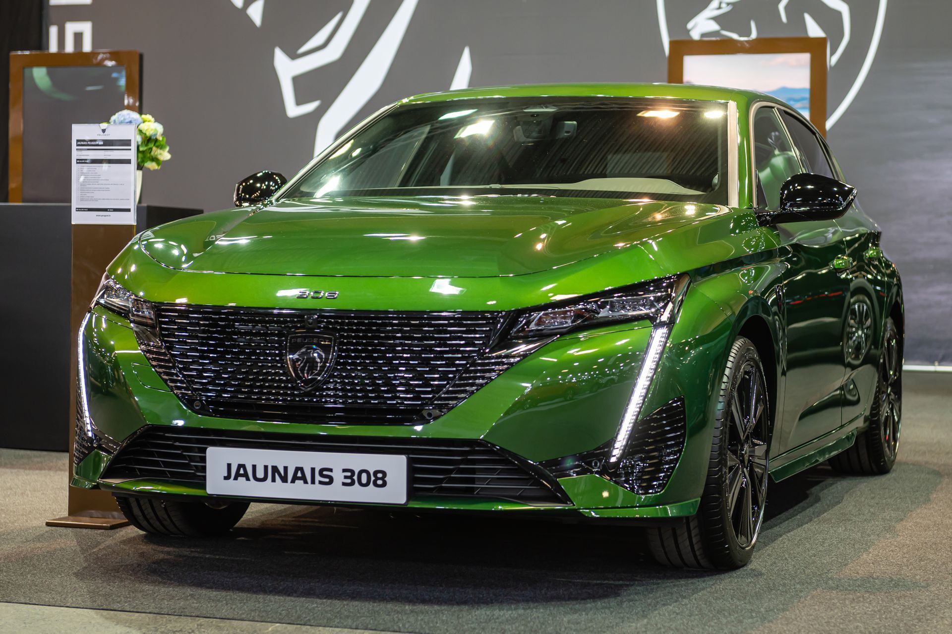 Voiture verte de la marque Peugeot exposée dans un salon.