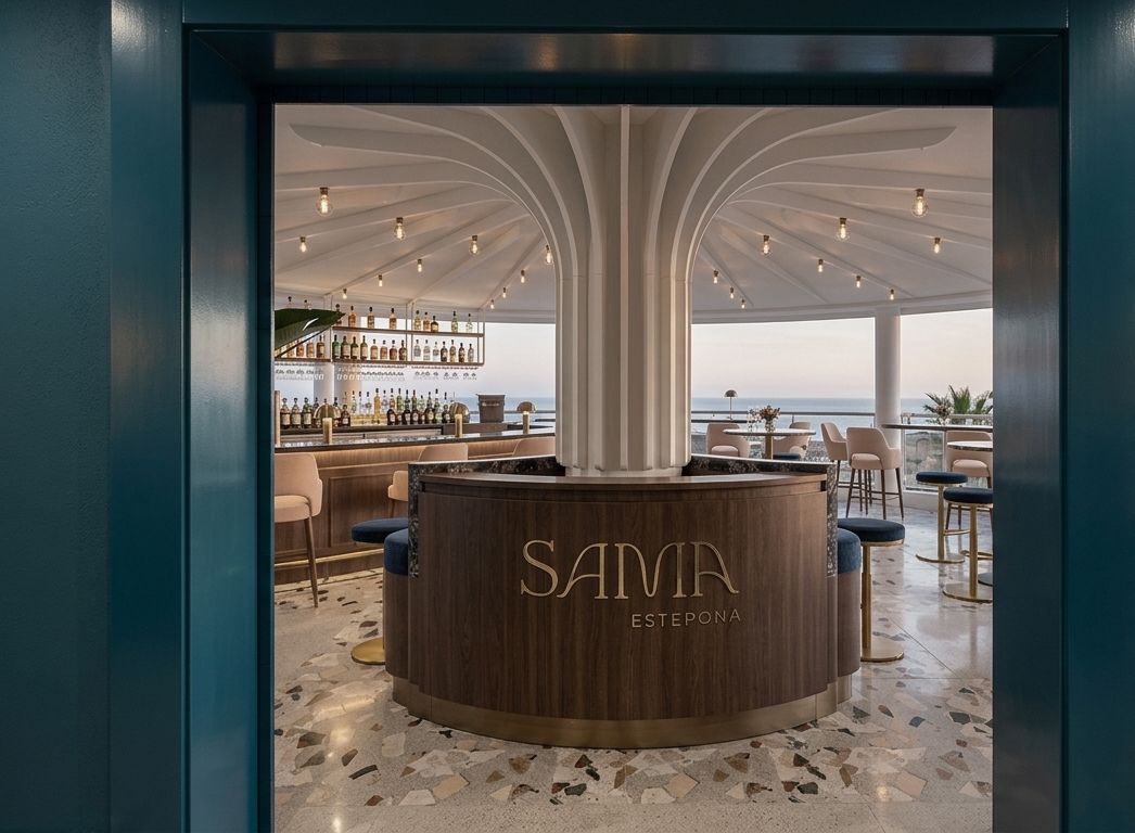 Interior de bar moderno y elegante con barra de madera curvada, iluminación cálida y vistas al océano.