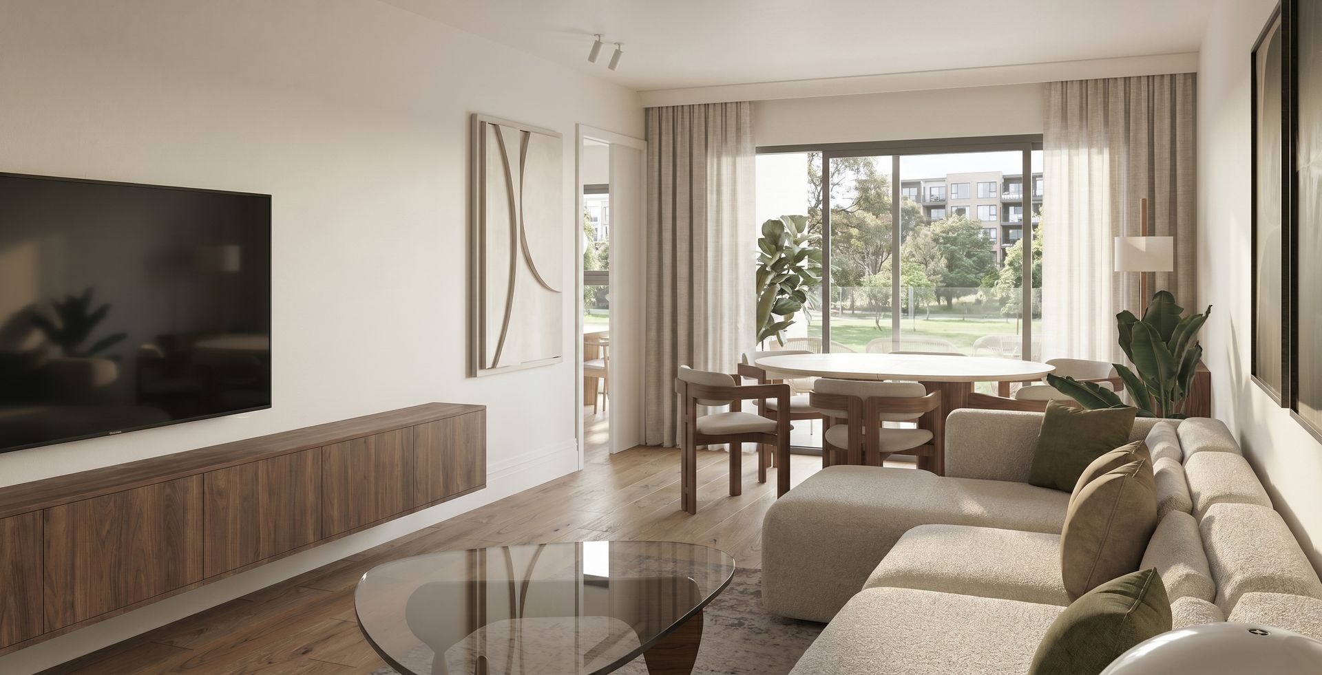 Sala de estar moderna con sofá seccional beige, televisor montado en la pared, mueble multimedia de madera y gran ventanal.