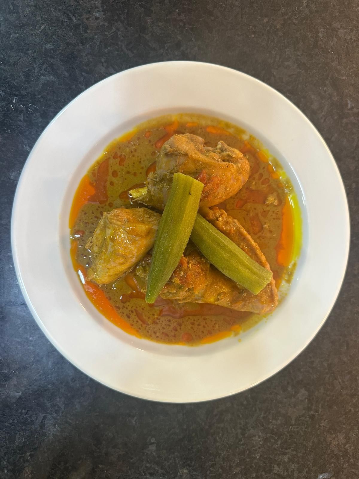 Um prato branco coberto com carne e vegetais sobre uma mesa.