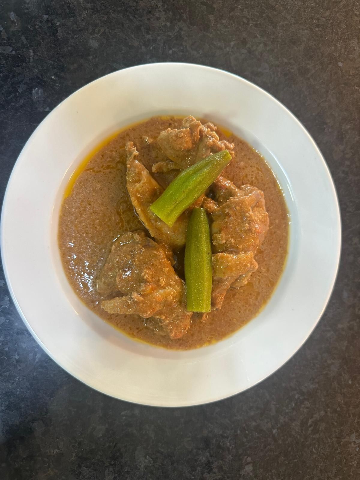 Uma panela preta cheia de camarão e rodelas de limão