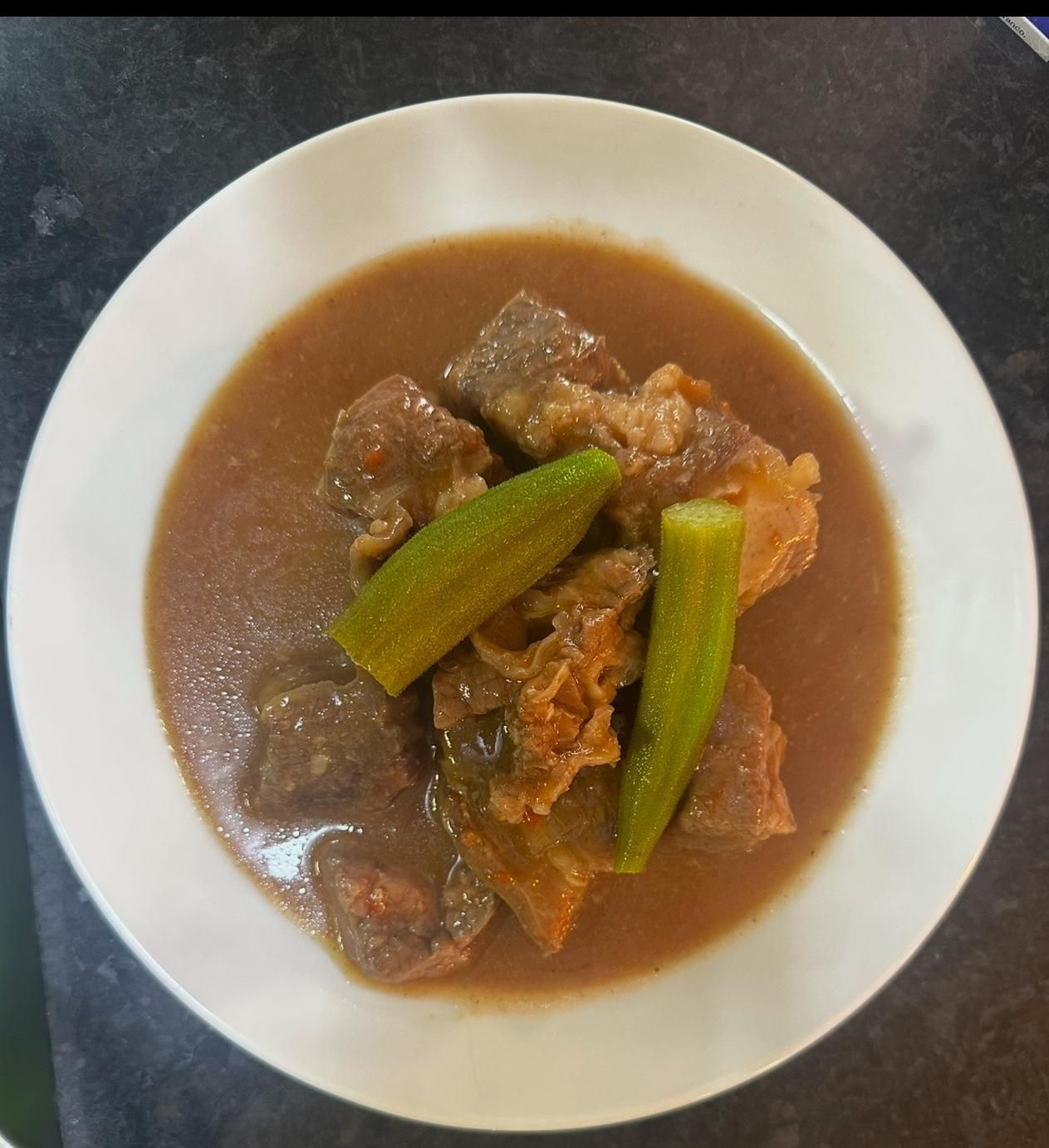 Uma tigela de comida com frutos do mar e arroz em uma mesa com talheres.