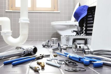 Werkzeug und weißes Rohr in einem Badezimmer