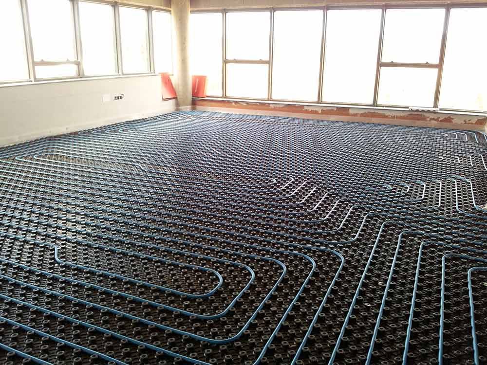 Una habitación con muchas ventanas y muchas tuberías en el suelo.