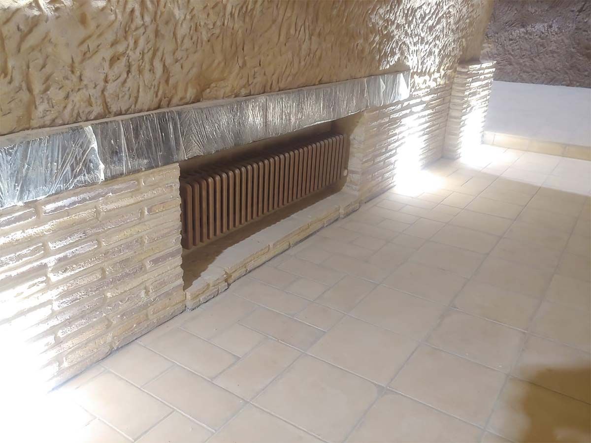 Una habitación con una pared de ladrillos y un piso de baldosas.