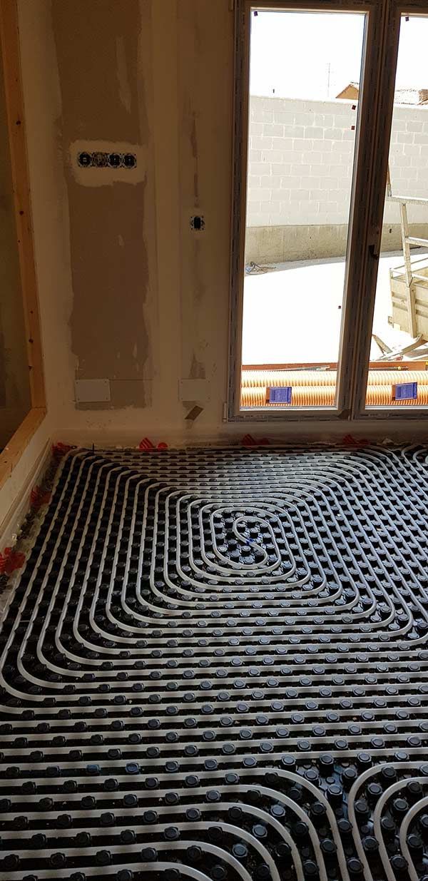 Una habitación con una puerta corrediza de vidrio y un sistema de calefacción por suelo radiante en blanco y negro.