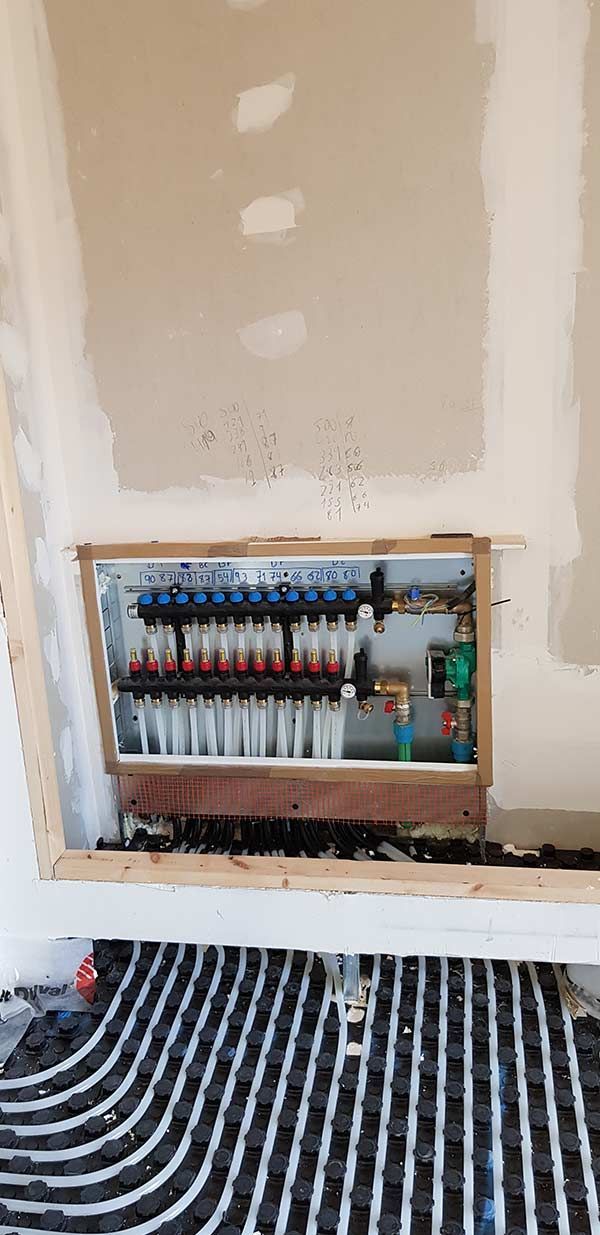 Se está instalando un sistema de calefacción en una habitación con suelo rayado.