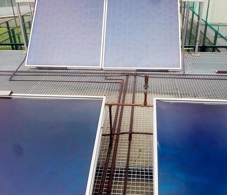 Una fila de paneles solares sobre una rejilla metálica.