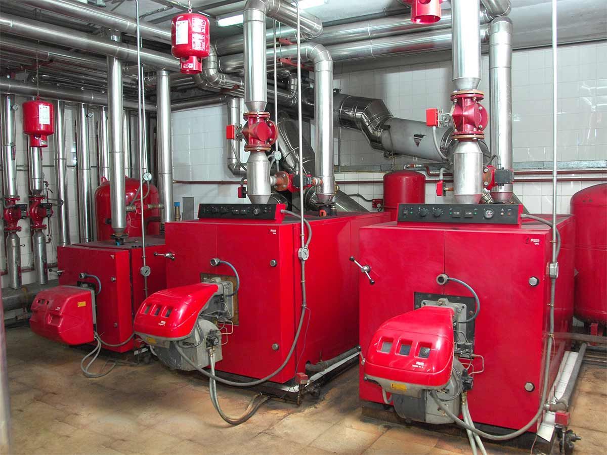 Hay tres calderas rojas una al lado de la otra en una habitación.