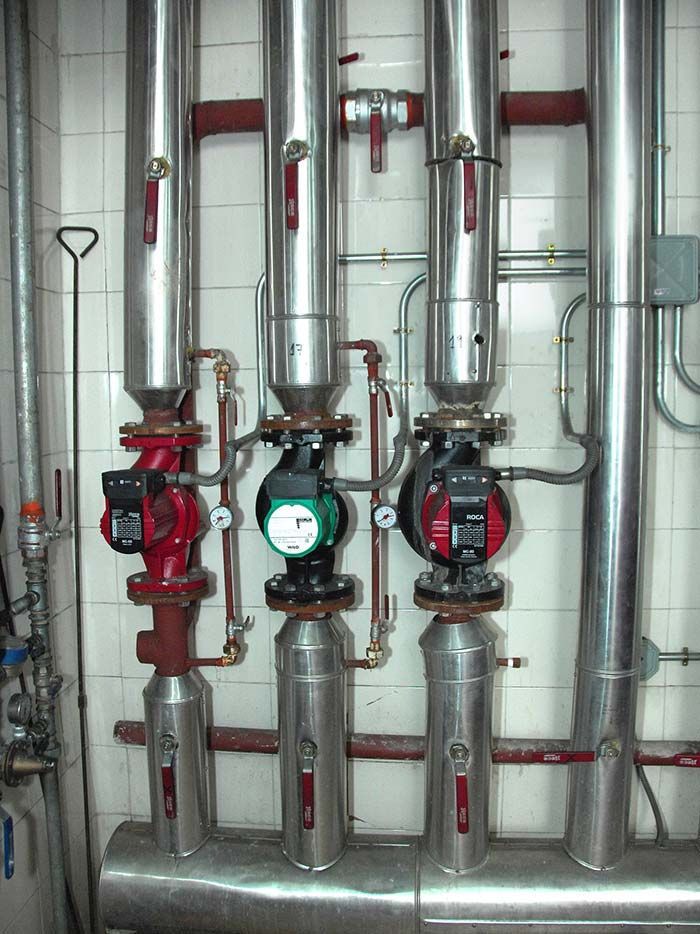 Una hilera de tubos de acero inoxidable con relojes en ellos.