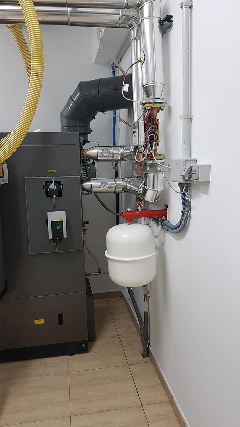 Una caldera está situada en una habitación al lado de una pared.