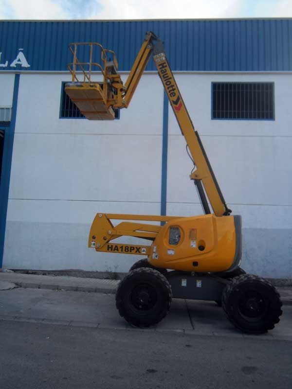 Un ascensor amarillo ha16fc está estacionado frente a un edificio