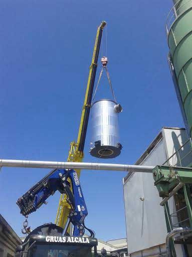 Se está levantando un objeto metálico de gran tamaño mediante una grúa.