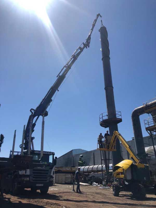 Se está utilizando una grúa grande para levantar una estructura muy alta.