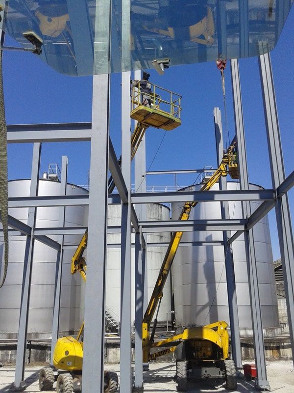 Una grúa amarilla está trabajando en una estructura metálica.