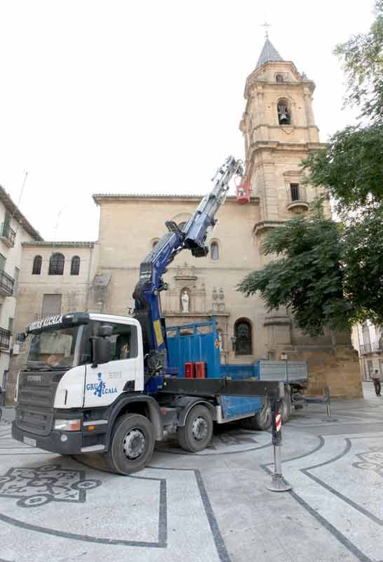 Un camión con una grúa en la parte trasera está estacionado frente a una iglesia.