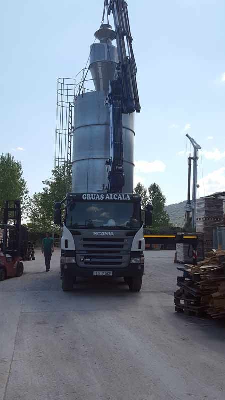 Un camión con una grúa encima está estacionado en un estacionamiento.