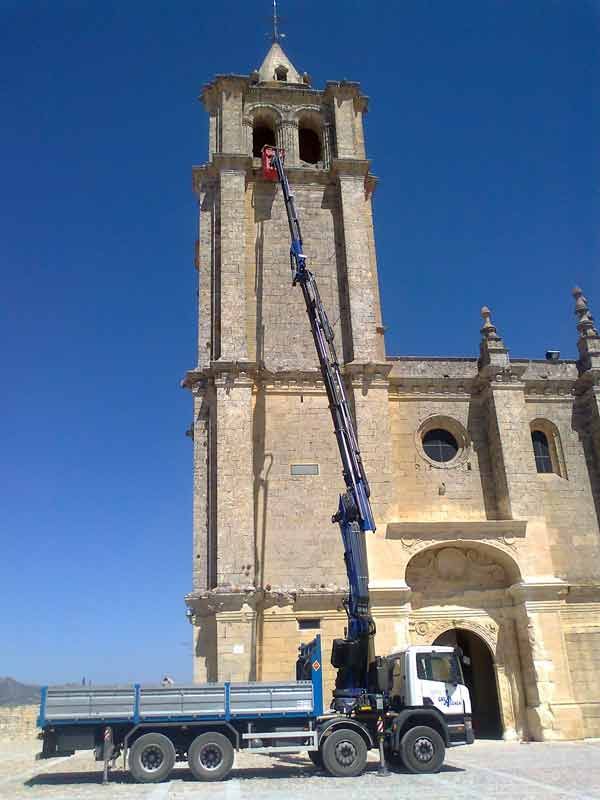 Un camión está estacionado frente a un edificio muy alto.