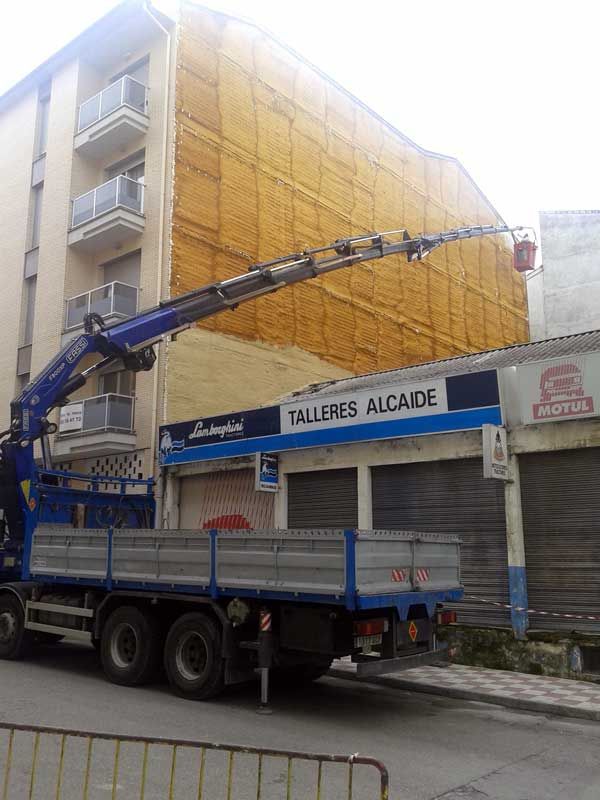 Un camión está estacionado frente a un edificio que dice talleres alcalde