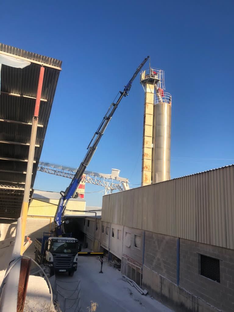 Una gran grúa está parada frente a un edificio.