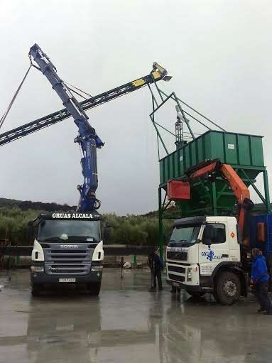 Un camión está siendo levantado por una grúa en un estacionamiento.