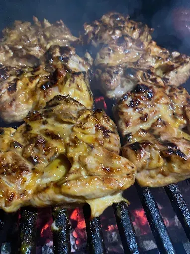 El pollo se cocina en una parrilla sobre el fuego.