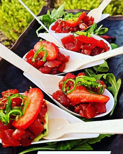 Cucharas llenas de tomates y pimientos verdes sobre una mesa